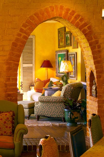 Orange brick arch glows with light from red and cream colored lamp shades