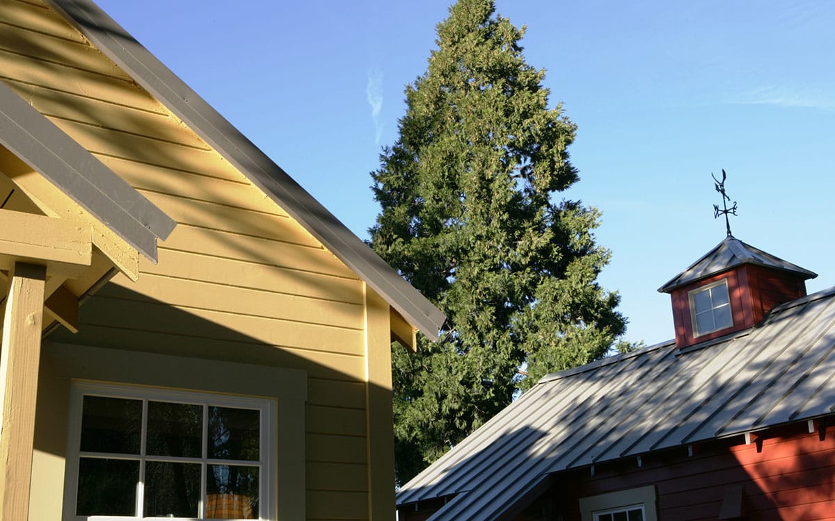Gray metal roofs combine with old fashioned cupolas to create a contemporary country look.