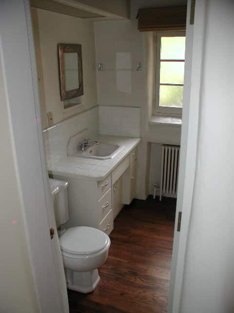 Before a low florescent lit soffet hung over the vanity and toilet in the tiny bathroom