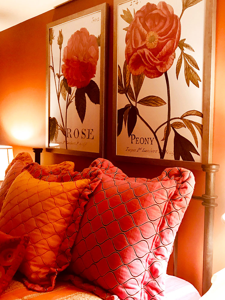 Coral and white floral artwork illuminates the guest room.