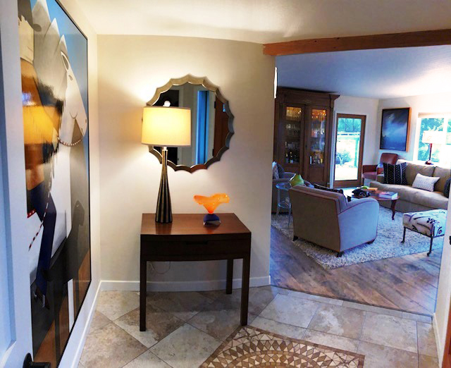 A mirror, lamp and table welcome guests where a unnecessary opening once existed.