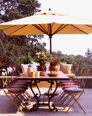 A flax-colored umbrella filters the sun's rays that shimmer on this Sonoma patio