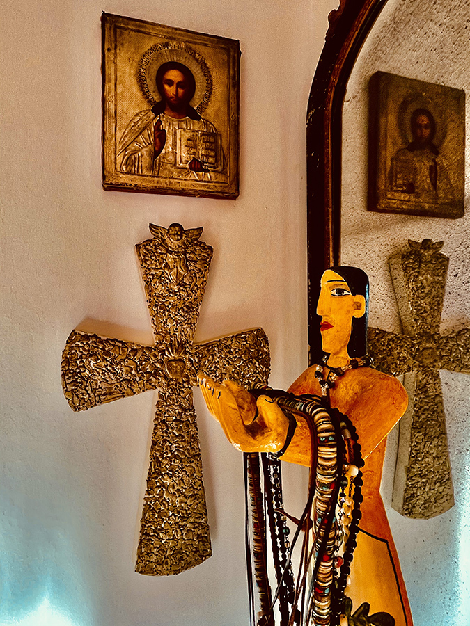 Image of Our Lady of the Harvest stands beside a Milagro cross from Mexico.