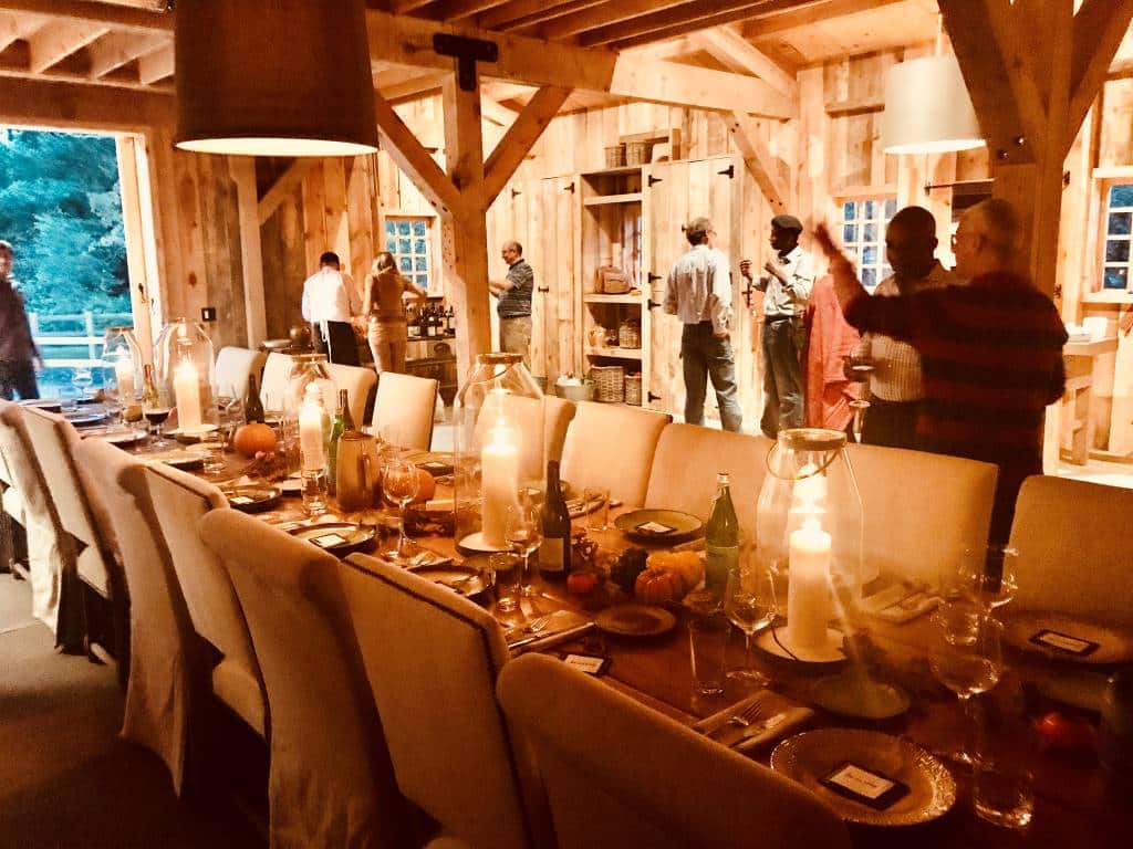 guests mingling in barn with festive table for feast